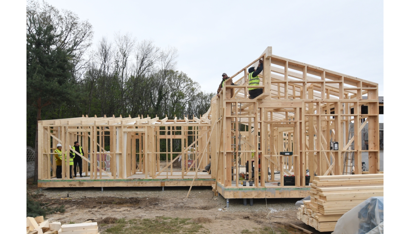 Casă nZEB din lemn cu structură timberframe în timpul șantierului, la marginea pădurii.